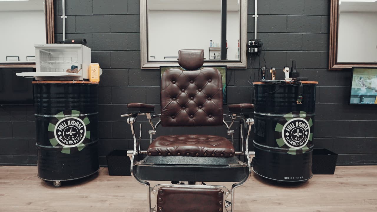Vintage leather barber chair between two branded barrels