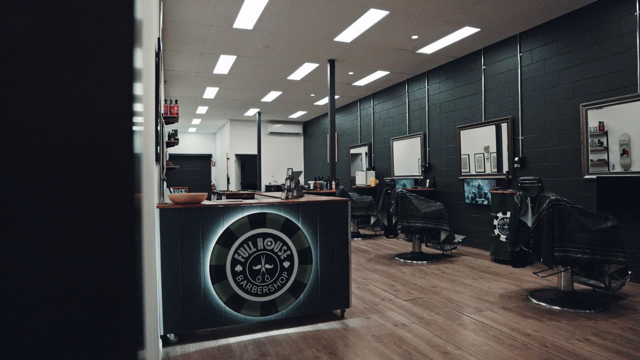 Fullhouse Barbershop interior with the poker-chip logo on the counter
